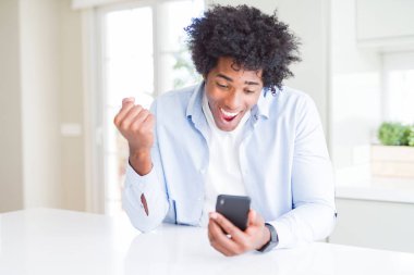 Gurur çığlık ve zafer ve başarı çok heyecanlı kutluyor akıllı telefon kullanarak Afrikalı Amerikan adam, tezahürat duygu