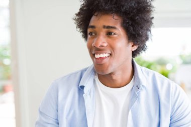 Afro saçlı yakışıklı Afrikalı Amerikalı adam görünümlü yan ve uzak düşünme bakıyor.