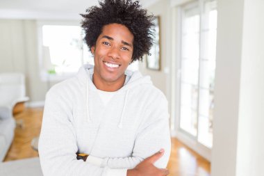 Afrikalı Amerikan adam Sweatshirt mutlu yüz kamera bakarak çapraz silah ile gülümseyen giyiyor. Pozitif kişi.