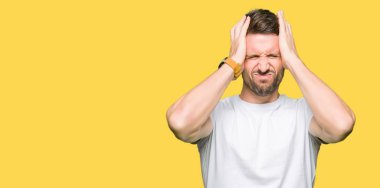 Yakışıklı adam çünkü umutsuz ve stresli baş ağrısı acı casual beyaz t-shirt giyen ağrı ve migren. Ellerini kafasına.