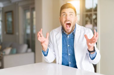 Klinikte genç yakışıklı doktor deli ve deli bağırarak ve agresif ifade ve kollar kaldırdı ile bağırıyor. Hayal kırıklığı kavramı.