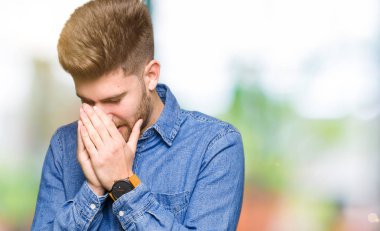 Üzgün ifade yüz eller ile ağlayarak süre kapsayan ile rahat kot gömlek giymiş genç yakışıklı sarışın adam. Depresyon kavramı.