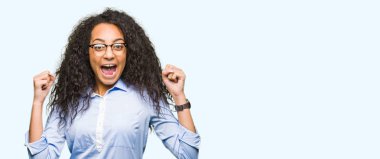 Silah ile şaşırmış ve hayret için başarı kutluyor gözlük takan kıvırcık saçlı Genç güzel iş kız kaldırdı ve gözleri açık. Kazanan kavramı.