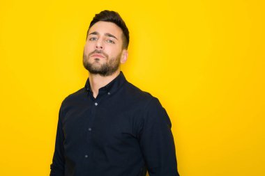 Genç yakışıklı adam possing ve modelleme sarı izole bac üzerinde