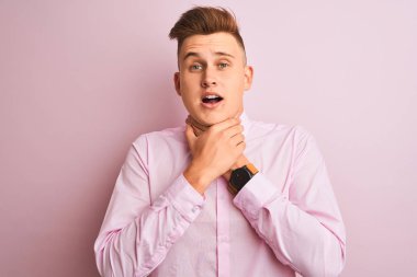 Genç yakışıklı işadamı izole pembe arka plan üzerinde duran zarif gömlek giyen bağırarak ve boğulma kısık çünkü acı boğmak. Sağlık sorunu. Boğulma ve intihar kavramı.
