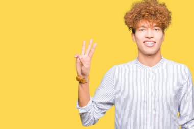 Şık gömlek gösterme ve parmakları ile işaret giyen afro saçlı Genç yakışıklı iş adamı kendinden emin ve mutlu gülümseyerek iken üçüncü.