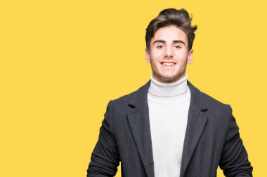 Yüzünde mutlu ve güzel bir gülümseme ile izole arka plan üzerinde kış ceket giyen genç zarif adam. Şanslı kişi.