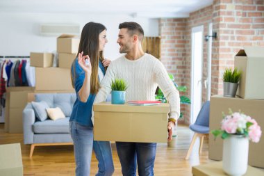 Genç çift yeni bir eve hareket, yeni dairenin anahtarlarını gösteren aşk sarılmak çok mutlu gülümseyen