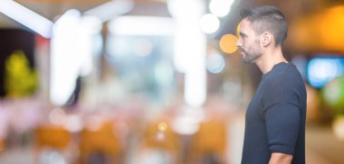 Genç yakışıklı adam giyen kazak izole arka tarafına, seyir üzerinde dinlenmek doğal yüz emin gülümseme ile pozuyla profili.