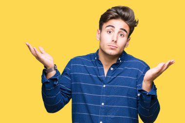 İzole arka plan clueless ve şaşkın bir ifadeyle kollar ve eller kaldırdı üzerinde Donanma gömlek giymiş yakışıklı delikanlı. Şüphe kavramı.