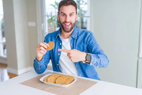 Όμορφος Άντρας Που Τρώει Υγιές Μπισκότο Ολικής Άλεσης Πολύ Χαρούμενο — Φωτογραφία Αρχείου
