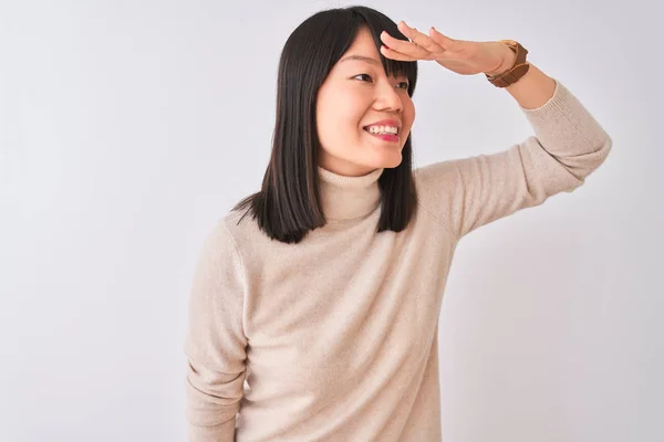 孤立した白い背景の上にタートルネックのセーターを着た若い美しい中国人女性は 頭の上に手を持って遠くに見て非常に幸せで笑顔 概念の検索 — ストック写真