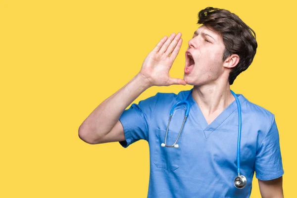 年轻的医生穿着医疗制服 在孤立的背景下大声喊话 用手放在嘴边尖叫 沟通理念 — 图库照片
