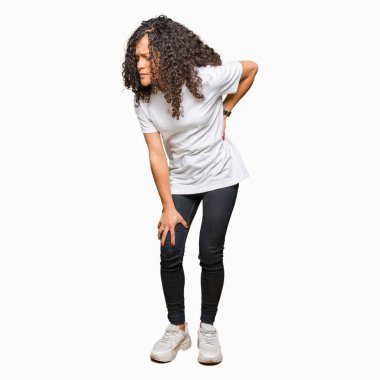 Kıvırcık saçlı beyaz t-shirt acı sırt ağrısı, el ile geri, kas ağrısı dokunmadan giyen genç güzel kadın