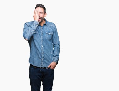 El yüz ve sürpriz duygu kendinden emin gülümseme ile tek gözüyle kapsayan izole arka plan üzerinde genç yakışıklı adam.