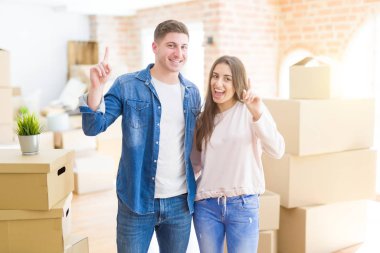 Güzel genç çift yeni bir ev başarılı bir fikir ile parmak işaret hareket. Çıkıldı ve mutlu. Bir numara.