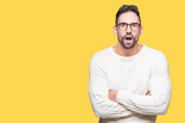 Korkuyor ve şok sürpriz ifade, korku ve heyecan yüz ile izole arka plan üzerinde gözlük takan genç yakışıklı adam.