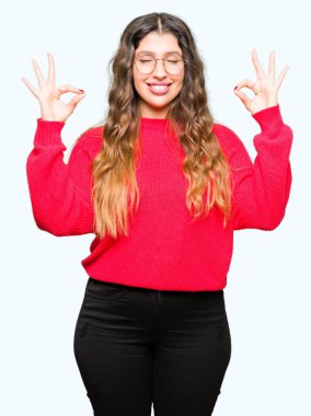 Genç güzel kadın kırmızı gözlük rahatla ve gülümseyen gözlerle kapalı parmak jestle meditasyon yapıyor. Yoga kavramı.