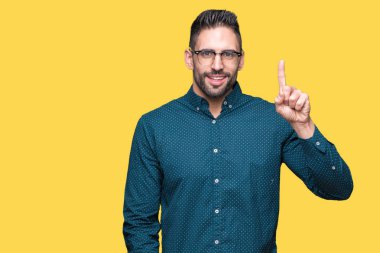 Ve parmak gülümseyen süre bir numara ile kendinden emin ve mutlu yukarıyı gösteren izole arka plan üzerinde gözlük takan genç yakışıklı iş adamı.