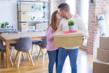 Yeni ev, yeni bir daire için çok mutlu ve neşeli karton kutular tutarak hareket aşk genç güzel çift