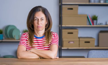 Orta yaş yaşlı kadın evde masada oturan depresif ve sıkıntı için endişe, kızgın ve korkmuş ağlıyor. Hüzünlü ifade.