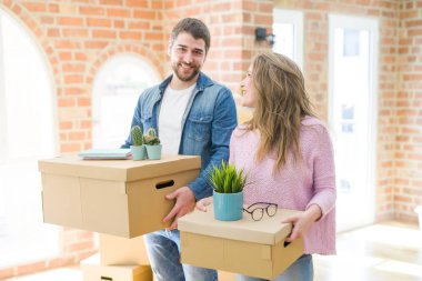 Yeni bir ev taşımak karton kutular tutarak birlikte çok mutlu genç güzel çift