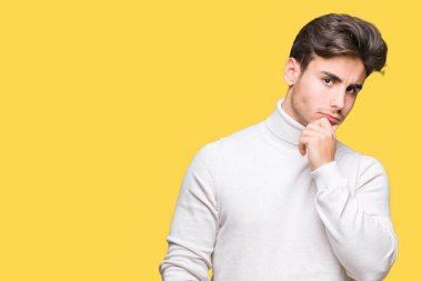 Çene düşünme hakkında soru, dalgın ifade üzerine el ile izole arka plan üzerinde boğazlı kazak giyen genç yakışıklı adam. Düşünceli yüzüyle gülümsüyor. Şüphe kavramı.