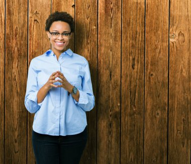 Genç güzel Afro-Amerikan iş kadını izole arka plan el ele tutusun ve parmaklar üzerinde rahat ve neşeli gülümseyen geçti. Başarı ve iyimser