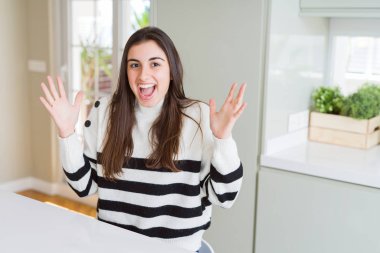 Güzel genç kadın çizgili kazak deli kutluyor giymiş ve silah ile başarı için hayran kaldırdı ve açık gözleri heyecanlı çığlık. Kazanan kavramı