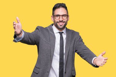 Genç yakışıklı iş adamı sarılmak için kollarını açarak gülümseyerek kameraya bakarak izole arka plan üzerinde. Neşeli ifade kucaklayan mutluluk.