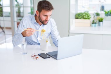 İş adam yeme Asya erişte yemek sırasında çalışma u götürün