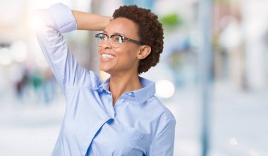 Çekici poz saç el jest, yukarı ile izole arka plan emin gülümseyen üzerinde genç güzel Afro-Amerikan iş kadına dokunmak