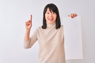 Genç güzel Çinli kadın izole beyaz arka plan üzerinde duran afiş tutan mutlu yüz, bir numara ile bir fikir veya soru işaret parmağı ile şaşırttı