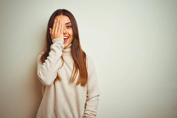 터틀넥 스웨터를 아름다운 여성은 손으로 얼굴에 자신감있는 미소와 감정을 가리는 — 스톡 사진