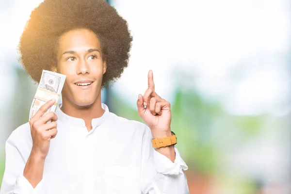 Joven Hombre Afroamericano Con Pelo Afro Sosteniendo Manojo Dólares Sorprendido —  Fotos de Stock