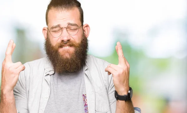 Joven Hombre Rubio Con Gafas Sonriendo Cruzando Los Dedos Con —  Fotos de Stock