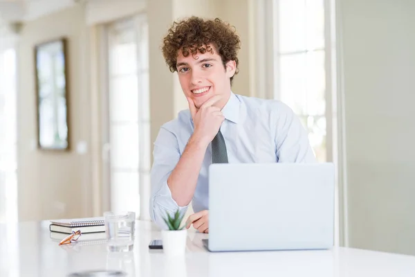 オフィスでコンピュータのラップトップで働く若いビジネスマンは 腕を組んで手を上げて笑顔でカメラを見つめています ポジティブな考え方 — ストック写真