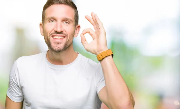 Hombre Guapo Vistiendo Casual Camiseta Blanca Sonriendo Positiva Haciendo Signo — Foto de Stock