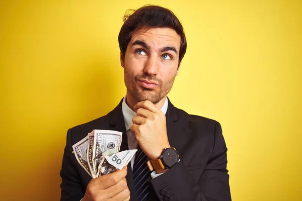 Young Handsome Businessman Wearing Suit Holding Dollars Isolated Yellow Background — Stock Photo, Image