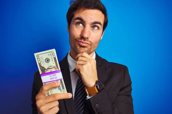 Junger Gutaussehender Geschäftsmann Anzug Der Dollars Über Isoliertem Blauem Hintergrund — Stockfoto