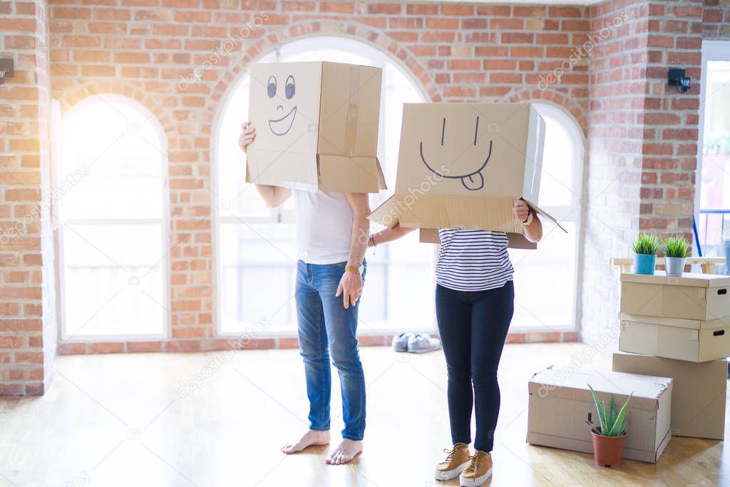 Couple wearing funny cardboard boxes with happy faces