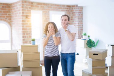 Orta yaş yaşlı çift hata için elleri ile ağız kapsayan şok etrafında kutuları ile yeni bir eve hareket. Gizli kavram.