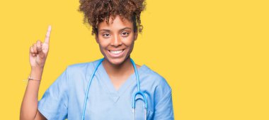 Genç Afro-Amerikan doktor kadın ve parmak gülümseyen süre bir numara ile kendinden emin ve mutlu yukarıyı gösteren izole arka plan.