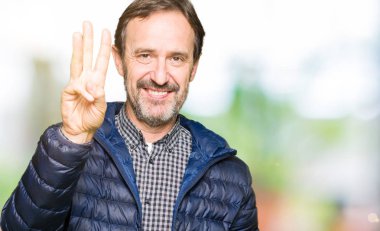 Kış ceket gösterme ve parmakları ile işaret giyen orta yaş yakışıklı adam kendinden emin ve mutlu gülümseyerek iken üçüncü.