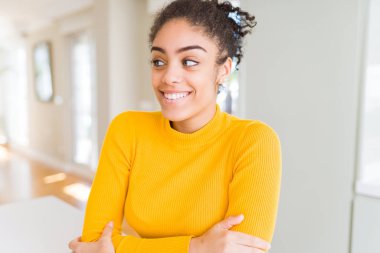 Afro saçlı görünümlü yan ve dik dik bakma uzağa düşünce gülümseyen güzel genç Afro-Amerikan kadın.