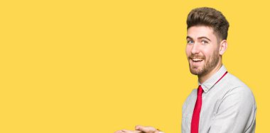 Genç yakışıklı iş işaretçi el yanında adam ve palm, mutlu ve kendine güvenen reklam gülümseyen sunulması açın