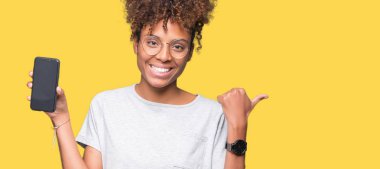 Genç Afro-Amerikan kadın gösteren smartphone ekran işaret ve başparmak kadar mutlu yüz gülümseyen tarafı ile gösteren izole arka plan üzerinde