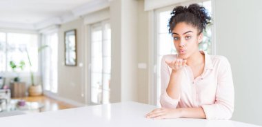 Afro saç güzel ve seksi olan hava el ile bir öpücük üfleme kamera bakarak hoş Afrikalı Amerikan kadın geniş açı. Aşk ifadesi.