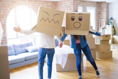 Çılgın çift kafa üzerinde komik yüzler ile kutuları giyiyor, yeni bir eve taşımak için mutlu eğlenceli