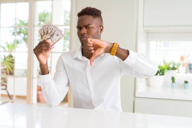 Kızgın yüz ile elli dolar banka banknotları tutan Afro-Amerikan adam, başparmak aşağı, ret kavramı ile sevmediğimi gösteren negatif işareti